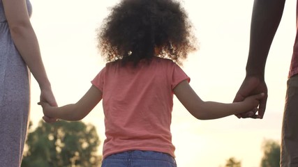 Perfect family holding hands, adopted child being supported by loving parents