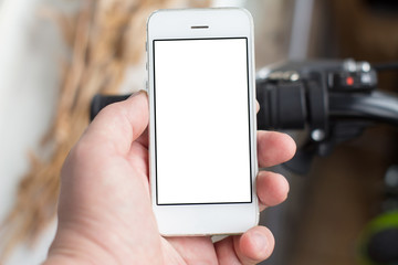 Man's hand use smartphone while he stands near by the road with bikes. With copy space