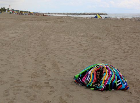 heap of towels abounding on the beach by an abusive seller after