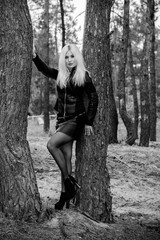 Fashion woman walking in autumn park. Cute woman in nature scenery. Glamorous woman wearing leather jacket and shirt