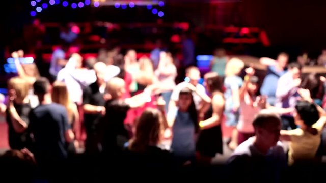 People dancing fun have a rest in night club. Party in nightclub, DJ playing music, a blurred background. People dancing on the dance floor