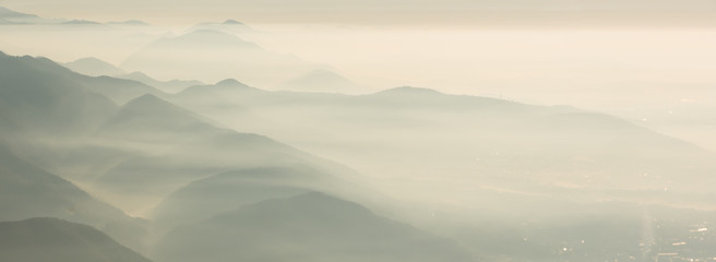 Morning landscape on hills and mountains with humidity in the air and pollution. Panorama from Linzone Mountain, Bergamo, Italy