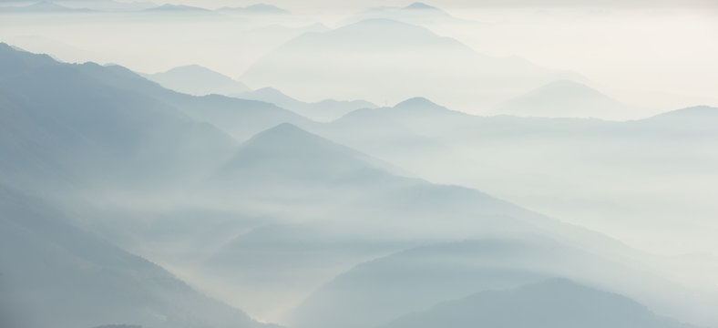 Morning landscape on hills and mountains with humidity in the air and pollution. Panorama from Linzone Mountain, Bergamo, Italy