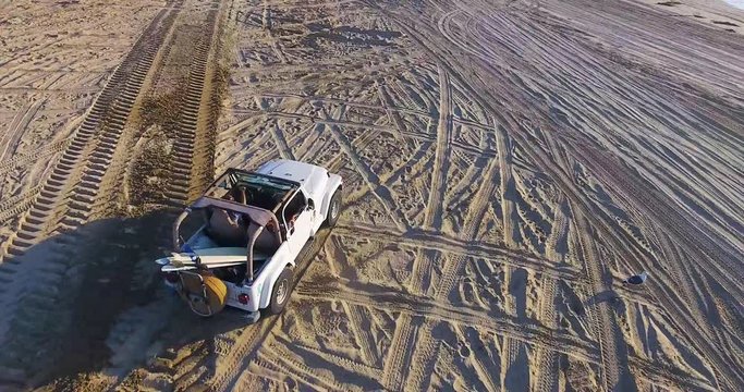 Drone actively following a Jeep on the beach 2