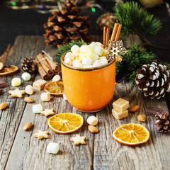 a cup of Christmas hot cocoa with marshmallow New Year's lights and decorations, selective focus
