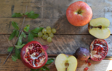 Autumn harvest concept - fruits on wooden table. Selective focus. Space for text. apple pomegranate grapes figs