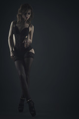 Woman in black lingerie on a dark background studio shot