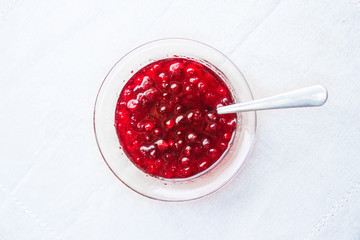 Jam in a vase top view on a white tablecloth