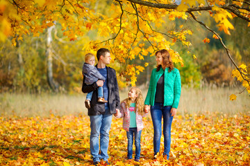Fototapeta premium happy family strolling in a beautiful autumn park.