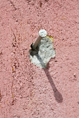 Nail on old pink wall 