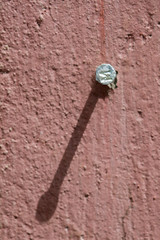 Nail on old pink wall 