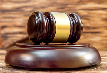 Wooden gavel with stand on wooden table. Close up.