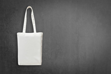 Eco cotton tote bag mock up white shopping fabric cloth sack with handle on blackboard background...