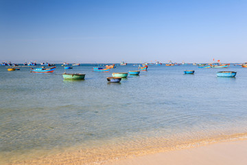 Fototapeta na wymiar Boats and basket boats at My Hiep beach in early morning, Ninh Thuan, Vietnam. Ninh Thuan is famous for beautiful landscapes, majestic Cham towers and unique Cham culture.