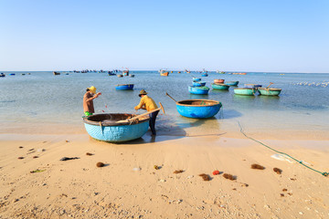 Obraz premium Fishermen are collecting fish at My Hiep beach in early morning, Ninh Thuan, Vietnam. Ninh Thuan is famous for beautiful landscapes, majestic Cham towers and unique Cham culture.
