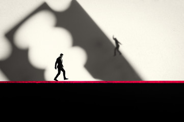 The concept of risk. A man in a business suit is walking along the razor's blade.