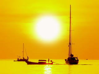 Fototapeta premium Silhouette of golden sunset and boat at sea background