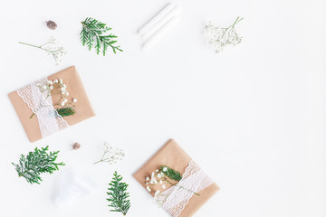 Christmas composition. Christmas gifts, pine cones, gypsophila flowers, thuja branches on white background. Flat lay, top view, copy space
