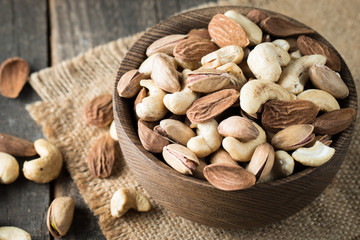 Healthy mix nuts on wooden background. Almonds, hazelnuts, cashews, peanuts, pistachios, brazilian nuts