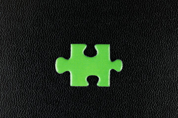 Green puzzles on a black leather
