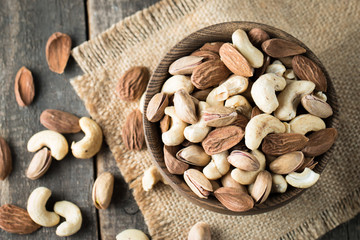Healthy mix nuts on wooden background. Almonds, hazelnuts, cashews, peanuts, pistachios, brazilian nuts