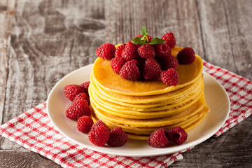 Fresh made delicious pancakes with berries, blackberries, raspberries, banana, honey and maple syrup. Healthy morning breakfast concept.