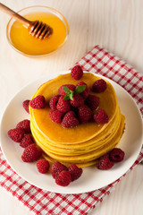 Fresh made delicious pancakes with berries, blackberries, raspberries, banana, honey and maple syrup. Healthy morning breakfast concept.