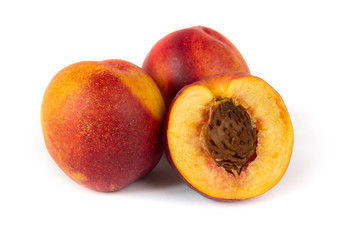 Three nectarine fruits with half cut one on white background