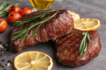 Delicious grilled steaks on grunge background