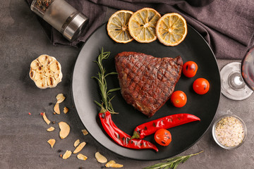 Plate with yummy steak on grunge background