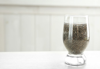 Glass of water with chia seeds on table