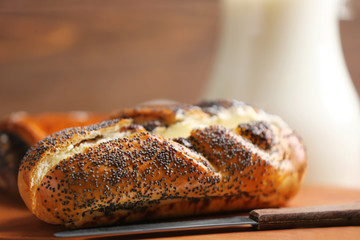 Tasty pastry with poppy seeds and butter on wooden board