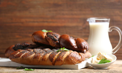 Tasty pastries with poppy seeds on wooden board