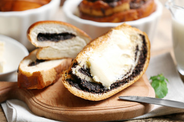 Sliced pastry with poppy seeds and butter on wooden board