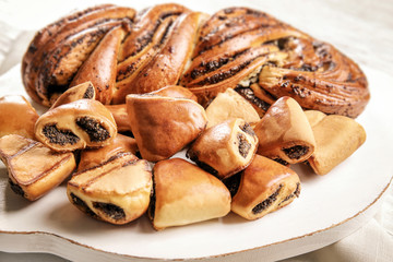 Tasty pastries with poppy seeds on wooden board