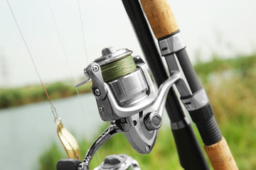 Spinning rod with fishing reel outdoors, closeup