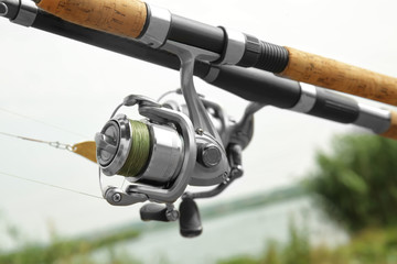 Spinning rod with fishing reel outdoors, closeup