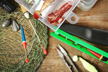 Modern fishing equipment on wooden table