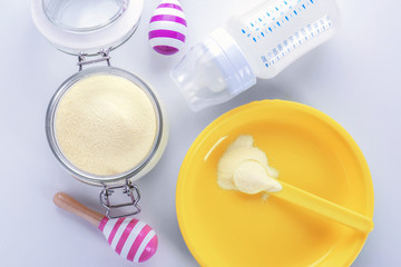 Composition with milk formula and baby bottle on white background