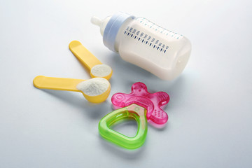 Baby milk formula and teether on white background