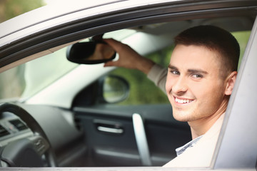 Handsome young man in modern car