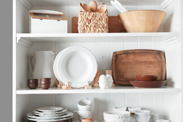Naklejka na ściany i meble Storage stand with tableware and kitchen utensils indoors