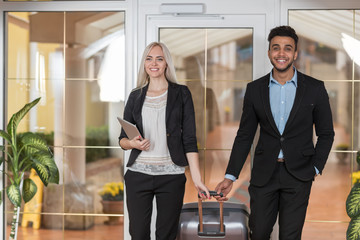Smiling Business Couple In Hotel Lobby, Businesspeople Group Man And Woman Guests Arrive Entrance With Suitcase