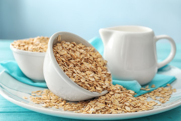 Bowls with oatmeal flakes and pitcher on ceramic dish