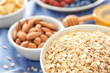 Bowl with oatmeal flakes on table, closeup