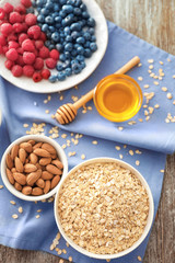 Composition with oatmeal flakes, almond, honey and berries on fabric