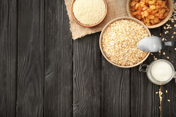 Oatmeal flakes, raisins and sugar on wooden background