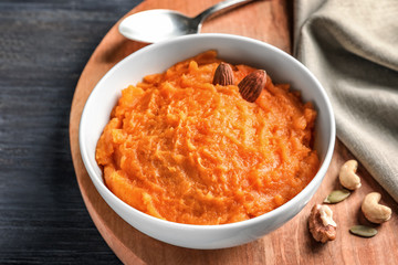 Bowl with mashed sweet potato on wooden board