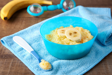 Bowl with porridge for baby on table