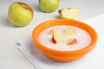 Bowl with porridge for baby on table